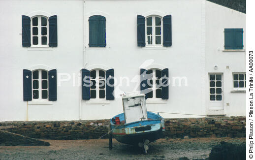 Un canot à moteur béquiller devant la maison aux volets bleus de Mane Verh. - © Philip Plisson / Plisson La Trinité / AA00073 - Photo Galleries - Boat
