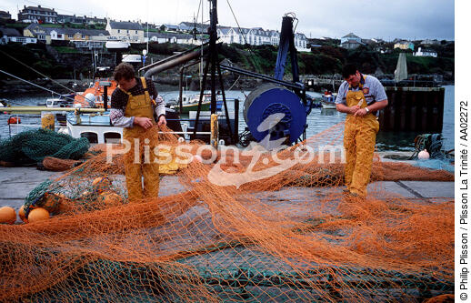Pêcheur réparant leur filet sur le port de Ballycotton. - © Philip Plisson / Plisson La Trinité / AA02272 - Nos reportages photos - Pêcheur