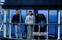 Gardiens de phare des Roches Douvres devant la lentille du phare. © Philip Plisson / Plisson La Trinité / AA03940 - Nos reportages photos - Roches Douvres [Les]