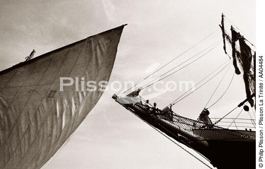 Le beaupré du Belem, suspendu entre ciel et mer, regarde passer le canot à misaine du bord. - © Philip Plisson / Plisson La Trinité / AA04484 - Nos reportages photos - Bout-dehors