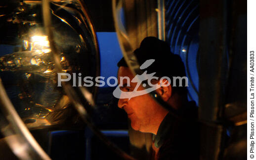 Gardien de phare devant la lentille du Pen-Men. - © Philip Plisson / Plisson La Trinité / AA03833 - Nos reportages photos - Métier