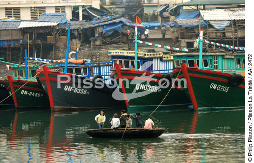 Barque devant l'étrave de bateaux de pêche dans le port d'Along. - © Philip Plisson / Plisson La Trinité / AA12472 - Nos reportages photos - Etraves